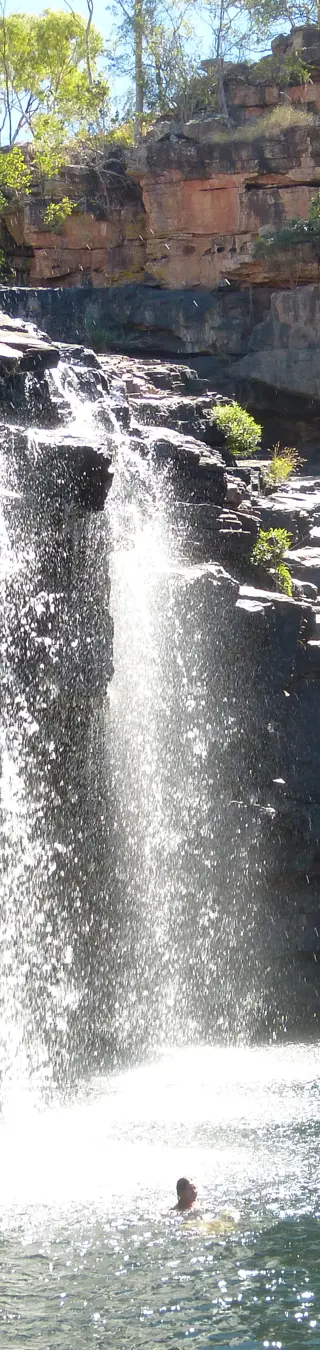 Schwimme unter einem Wasserfall